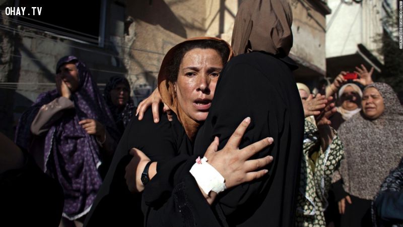 Người phụ nữ với vẻ mặt thất thần khi dự đám tang của 4 bé trai thiệt mạng do trúng tên lửa. Lúc này, các em đang chơi đùa trên bãi biển ở Gaza năm 2014. 