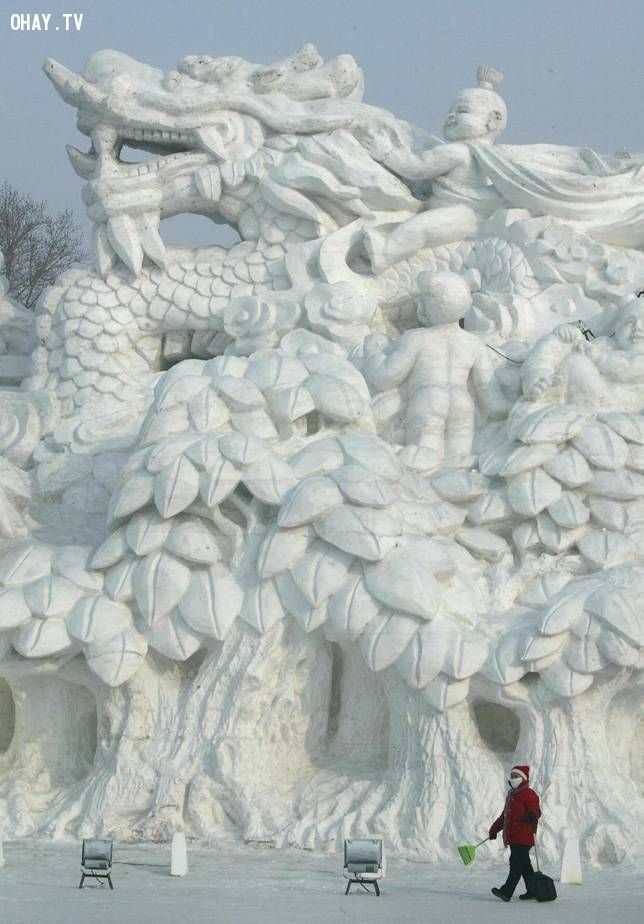 A snow sculpture of children riding a dragon